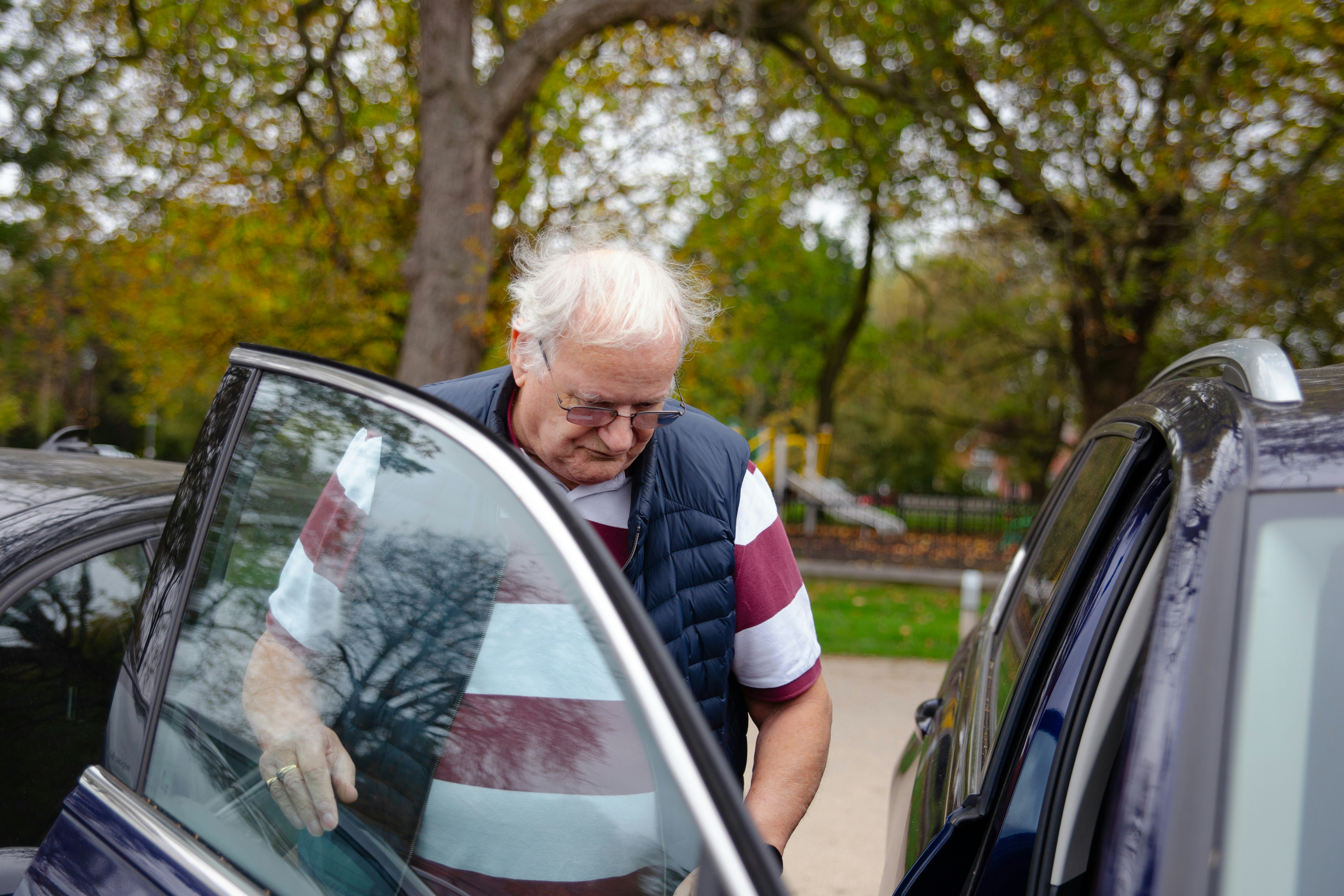 Older man getting into car to be driven to the doctors